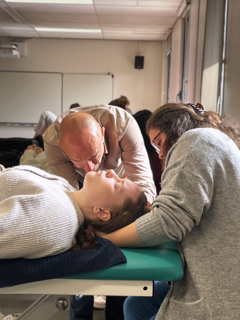 Formateur montrant une technique ostéopathique à une étudiante
